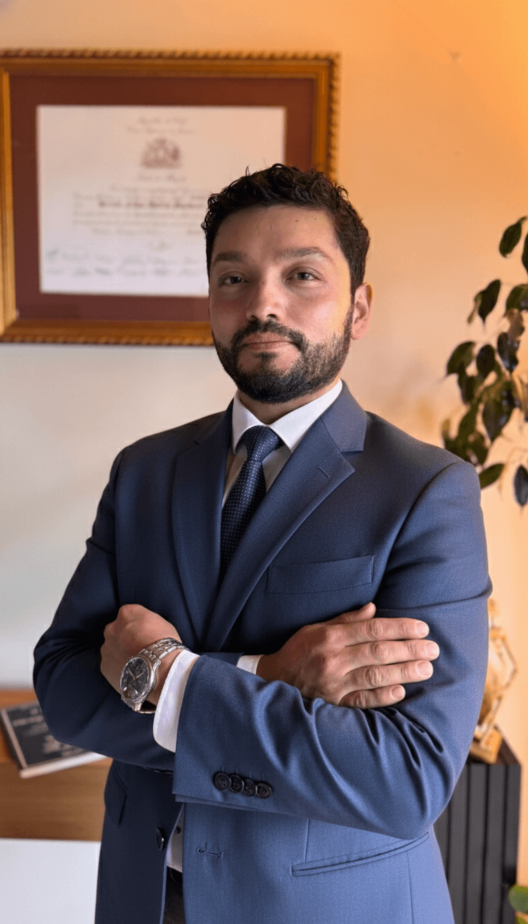 Abogado fundador de Magna Defensa, de traje azul y brazos cruzados, en su oficina